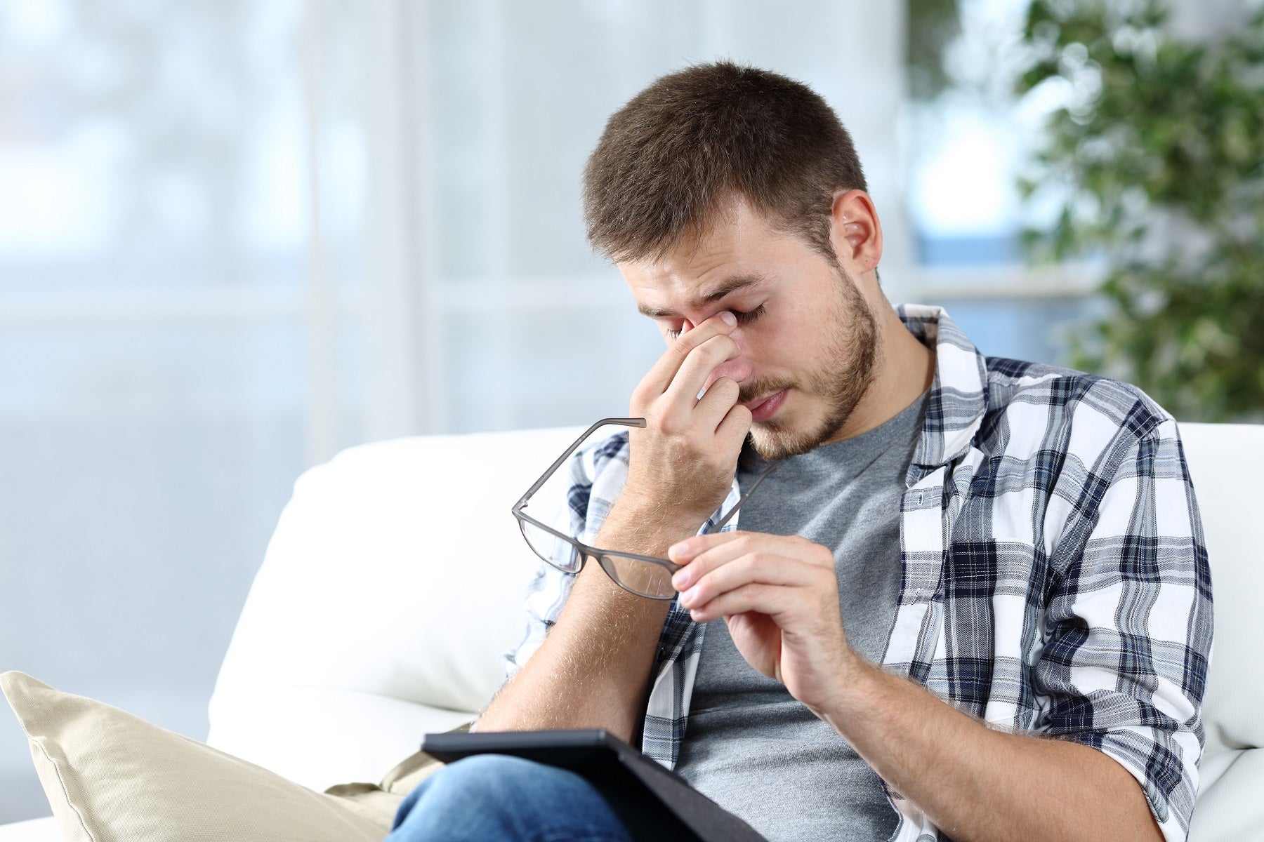 Man taking off eyeglasses suffering eyestrain